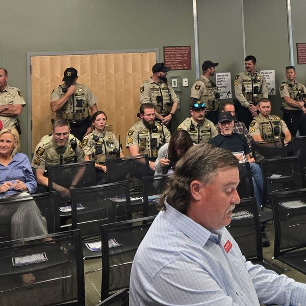 Thumbnail of Exhibit G, uniformed deputies along the back wall of the October 5 forum.